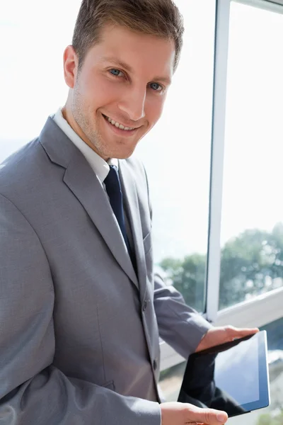 Biznesmen stojąc przy oknie z jego tabletki — Zdjęcie stockowe