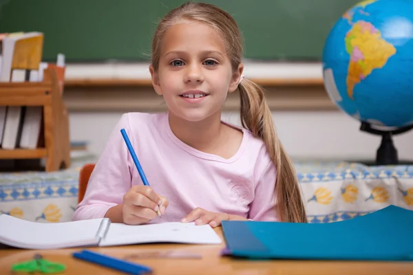 Lächelnde Schulmädchen schreiben — Stockfoto