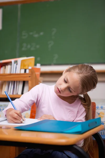Portrait d'une écolière concentrée écrivant — Photo