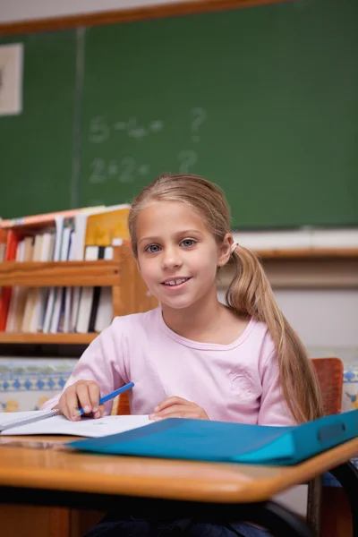 Portret van een schattige schoolmeisje schrijven — Stockfoto