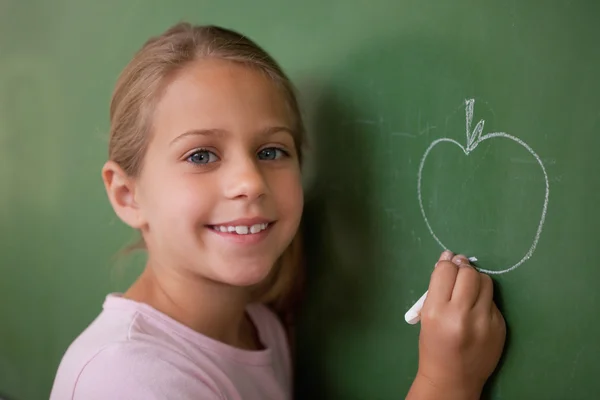 Escolar sonriente dibujando una manzana —  Fotos de Stock