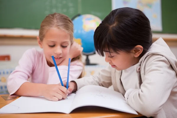 Glad skolflickor gör klassrumsarbete — Stockfoto