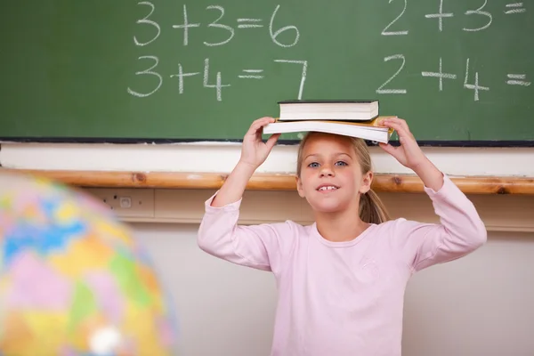 Ler skolflicka håller hennes bok på hennes huvud — Stockfoto