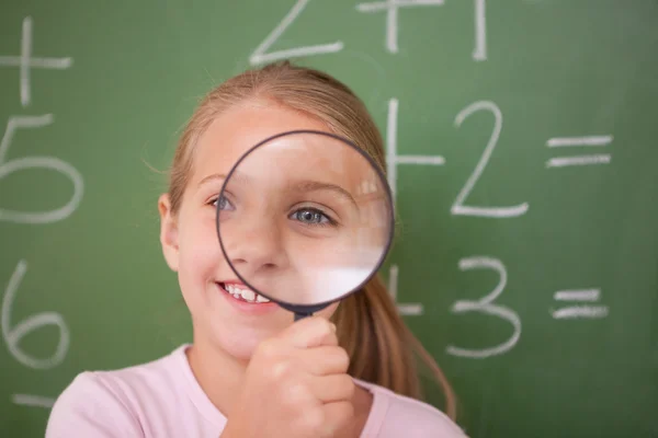 Studentessa guardando attraverso una lente di ingrandimento — Foto Stock