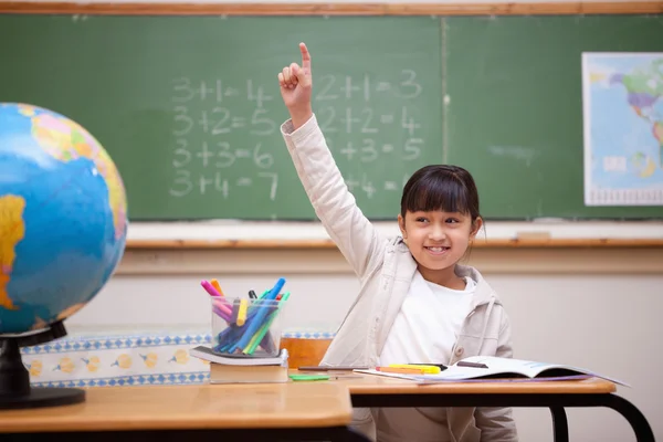 女子高生は彼女の手を上げる質問に答えるに笑みを浮かべてください。 — ストック写真