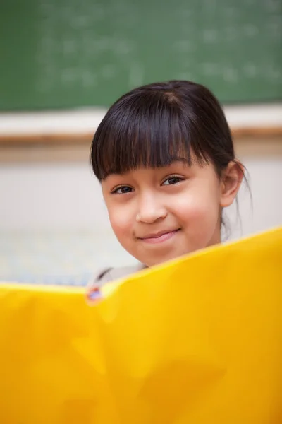 Portret van een glimlachende schoolmeisje lezing — Stockfoto