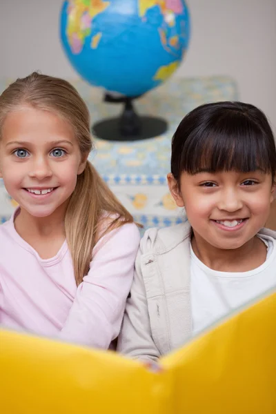 Porträtt av glad skolflickor läsning — Stockfoto