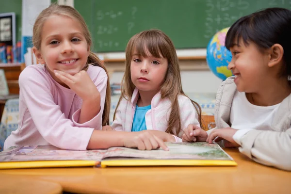 Skolflickor läsa en saga till sin klasskamrat — Stockfoto