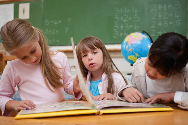 Schattig schoolmeisjes een sprookje lezen om hun klasgenoot — Stockfoto