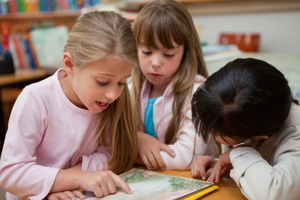 Schoolgirls reading a fairy tale together — Stockfoto