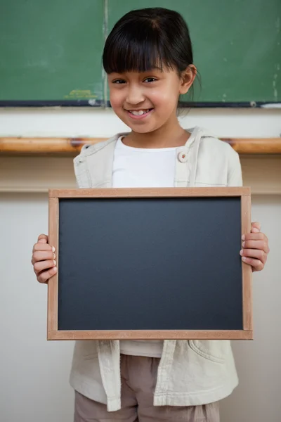 Retrato de uma menina segurando uma ardósia escolar — Fotografia de Stock