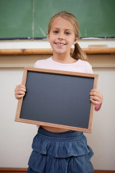Retrato de uma menina feliz segurando em uma ardósia escola — Fotografia de Stock