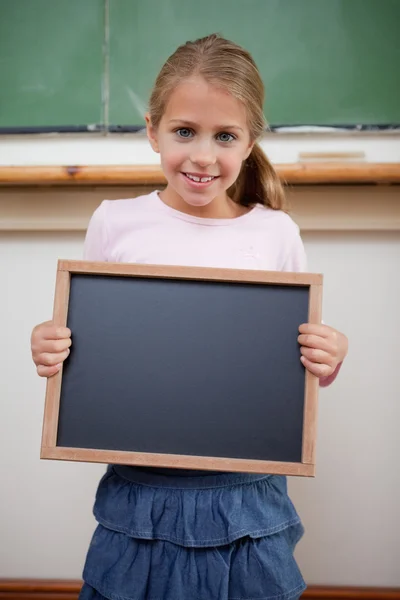 Porträt eines jungen Mädchens, das an einer Schultafel hält — Stockfoto