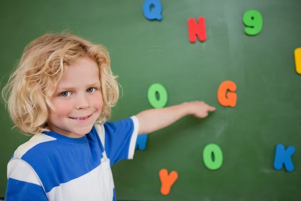 Schoolboy pointing at a letter — Stock Photo, Image