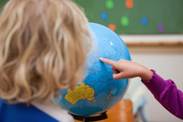 Finger eines kleinen Mädchens zeigt einem Klassenkameraden ein Land — Stockfoto
