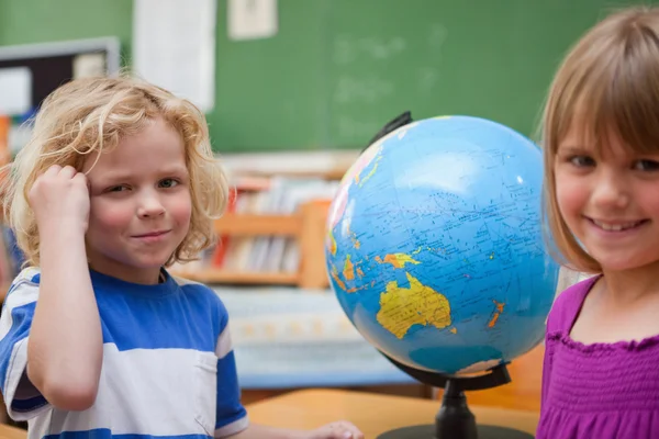 Leerlingen poseren voor een globe — Stockfoto