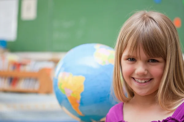 Écolière posant devant un globe — Photo