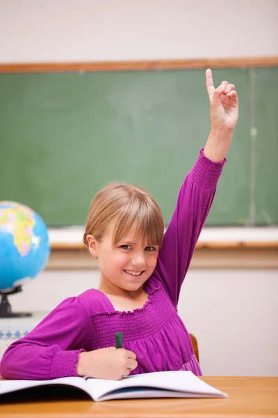 Портрет школьницы, поднимающей руку — стоковое фото