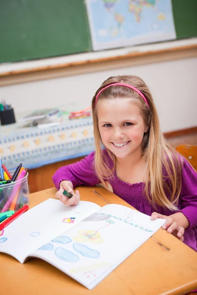 Portrait of a smiling schoolgirl drawing — Stock Photo, Image