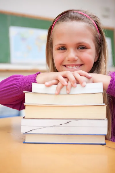 Porträt einer glücklichen Schülerin, die mit einem Stapel Bücher posiert — Stockfoto