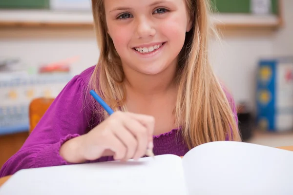 Primer plano de una joven colegiala escribiendo — Foto de Stock