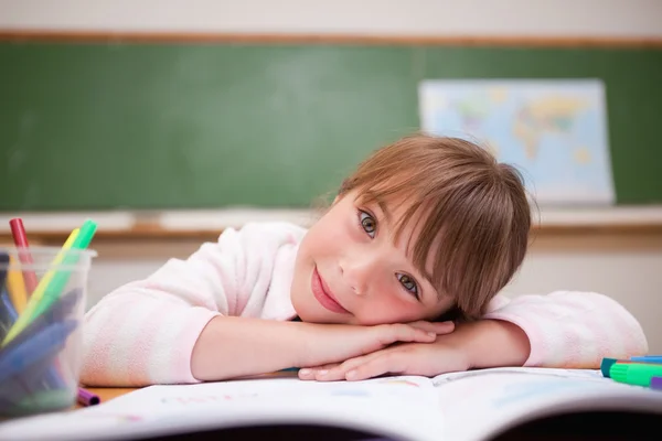Aranyos iskoláslány asztalon hajol — Stock Fotó