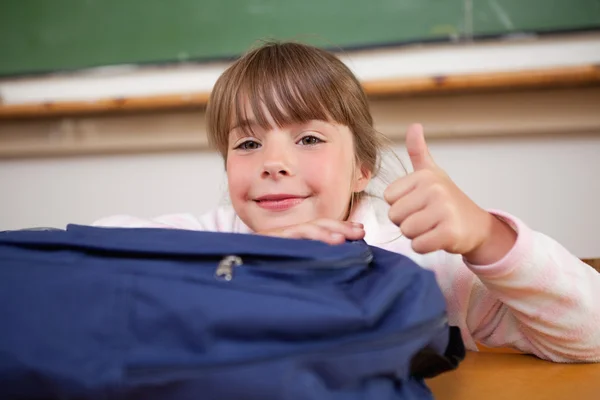 Roztomilá školačka pózuje s pytel a palec nahoru — Stock fotografie