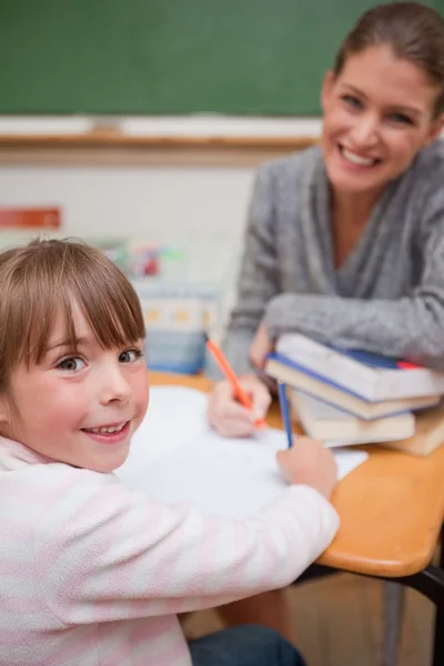 Портрет улыбающейся учительницы, объясняющей что-то своему ученику — стоковое фото