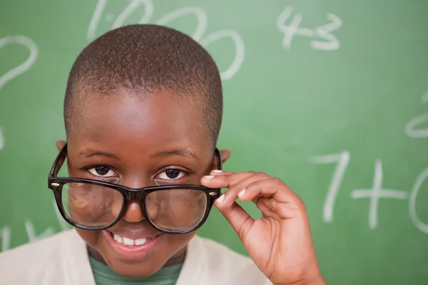 Smiling schoolboy looking over his glasses — Stock Photo, Image