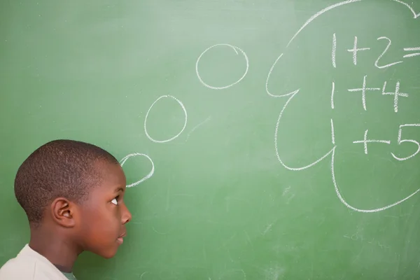 Schoolboy thinking about additions — Stock Photo, Image