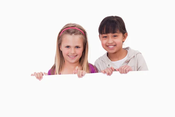 Girls behind a blank panel — Stock Photo, Image