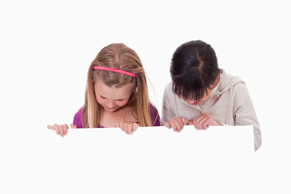 Girls looking at a blank panel — Stock Photo, Image