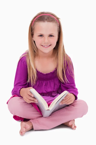 Retrato de uma menina feliz lendo um livro — Fotografia de Stock