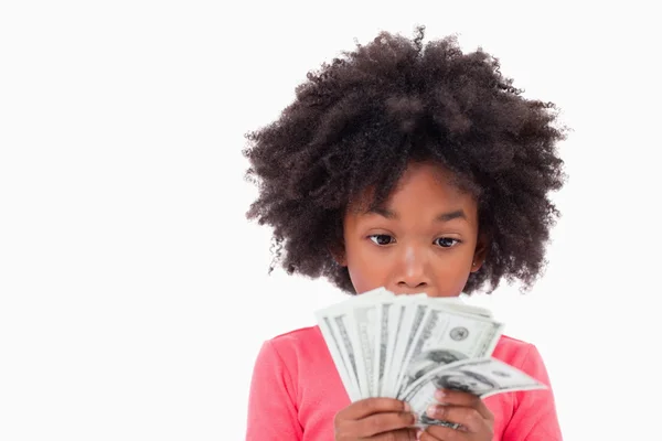 Mädchen schaut auf Geldscheine — Stockfoto