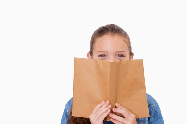 隐藏她的脸在一本书后面的女孩 — 图库照片