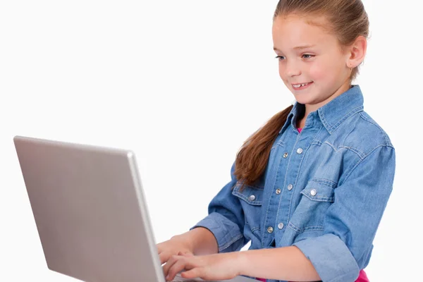 Leende flicka använder en bärbar dator — Stockfoto