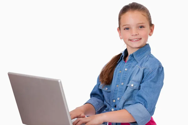 Bir dizüstü bilgisayar kullanan mutlu kız — Stok fotoğraf
