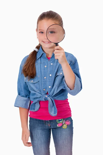 Portrait of a girl looking through a magnifying glass — Stock Photo, Image