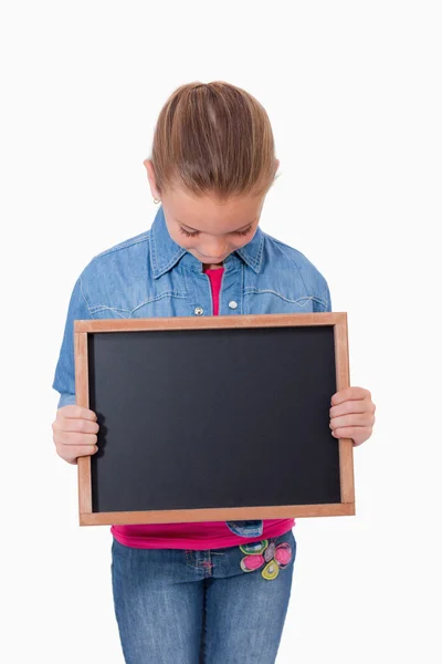 Portrait of a young girl looking at a school slate — Stock Photo, Image