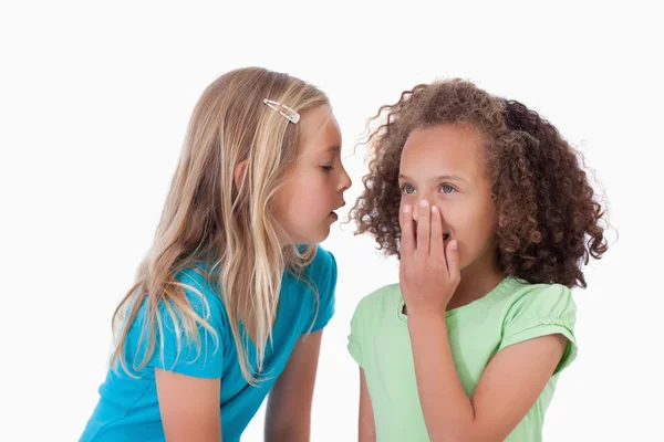 Menina sussurrando um segredo para seu amigo — Fotografia de Stock