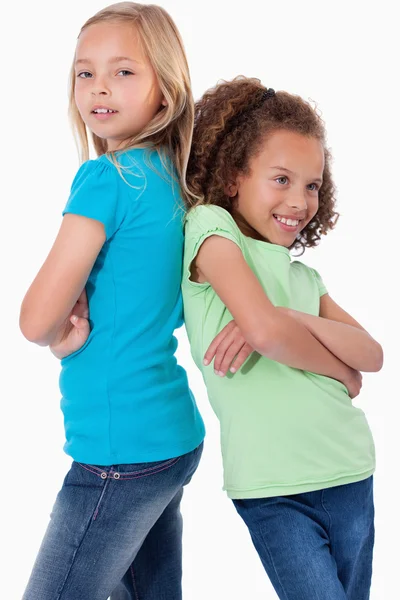 Portrait of smiling girls standing back to back — Stock Photo, Image