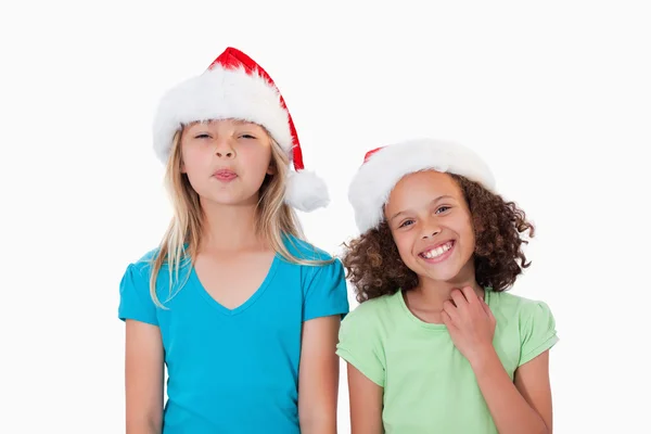 Fröhliche Mädchen mit Weihnachtsmützen — Stockfoto