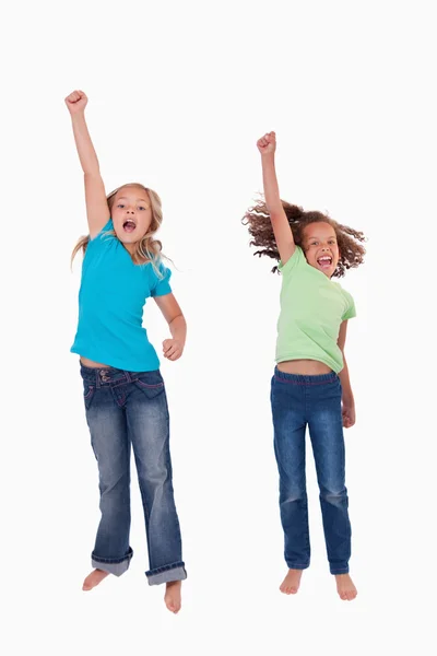 Portrait of girls jumping with their fists up — Stock Photo, Image