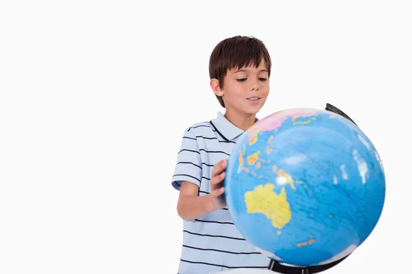 Garçon souriant regardant un globe — Photo