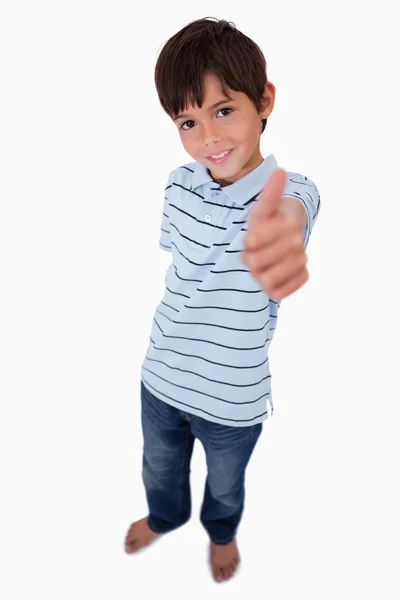 Портрет мальчика, улыбающегося в камеру с большим пальцем вверх — стоковое фото