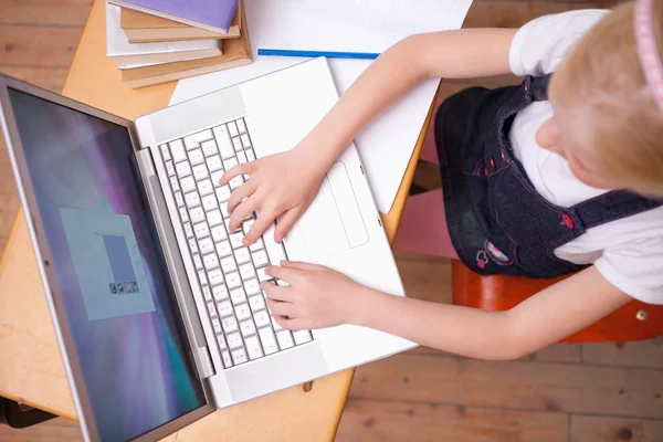 Bir kız görünümünü bir dizüstü bilgisayar kullanarak — Stok fotoğraf