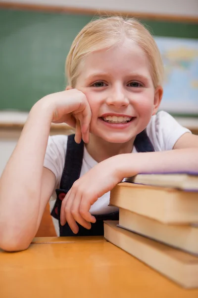 Портрет усміхненої дівчини, що спирається на книги — стокове фото
