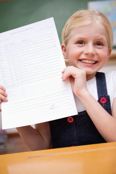 Портрет девочки, показывающей свой школьный отчет — стоковое фото