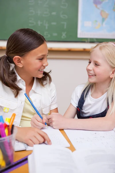 Portrait of happy pupils working together on an assignment — Stock Photo, Image