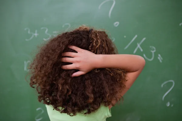Školačka přemýšlet o algebře při škrábání zadní h — Stock fotografie